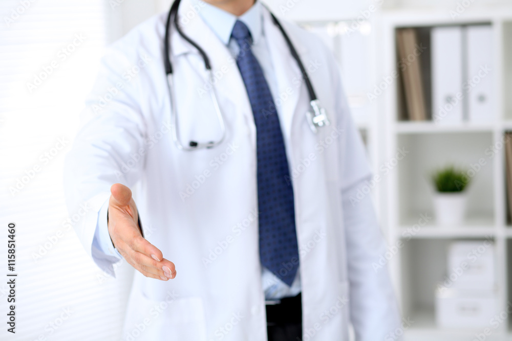 Male medicine doctor offering helping hand for handshake. Partnership and trust concept. Male medicine doctor offering helping hand for handshake. Partnership and trust concept.