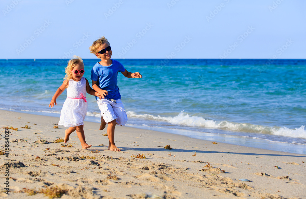 little boy and girl running at beach