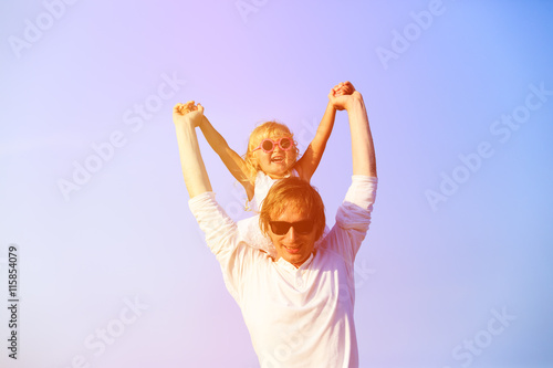 Father and little daughter play at sky
