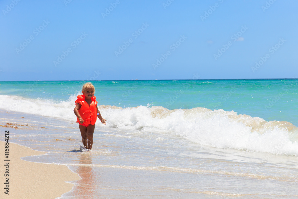 cute little girl in life jacket on summer beach, safety cute little girl in life jacket on summer beach, safety