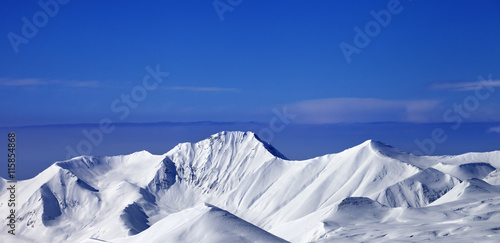 Panoramic view on snow mountains and blue sky