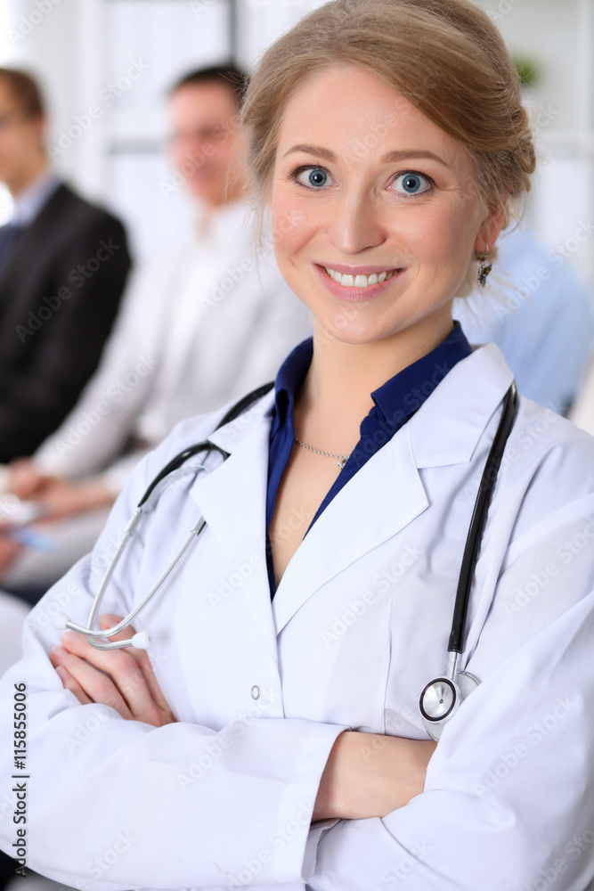 Happy doctor woman on the background doctor and many patients Happy doctor woman on the background doctor and many patients