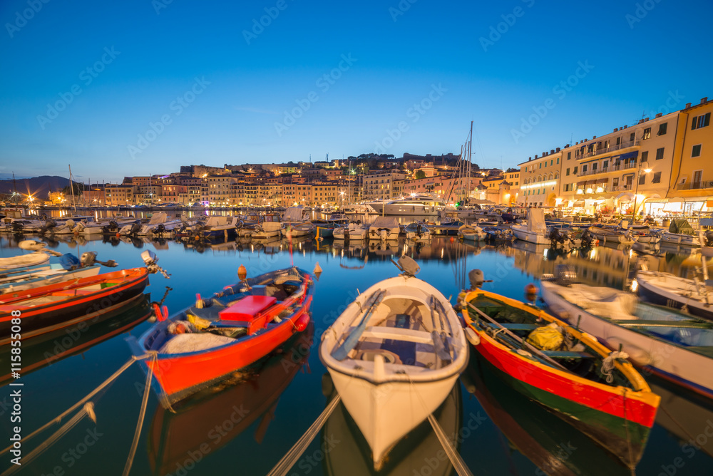 Traditional boats in Portoferraio port and coastline of Elba island in Italy