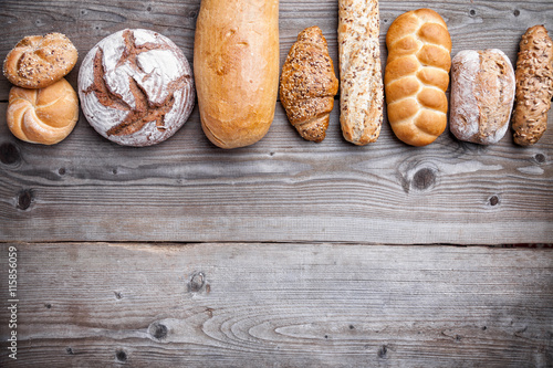 Delicious fresh bread on wooden background photo