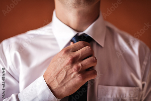 man putting on a tie