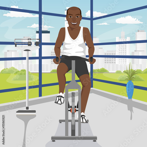 african american man doing exercise on bike at gym