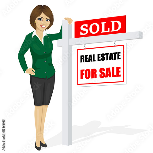 Female real estate agent standing next to a sold for sale sign