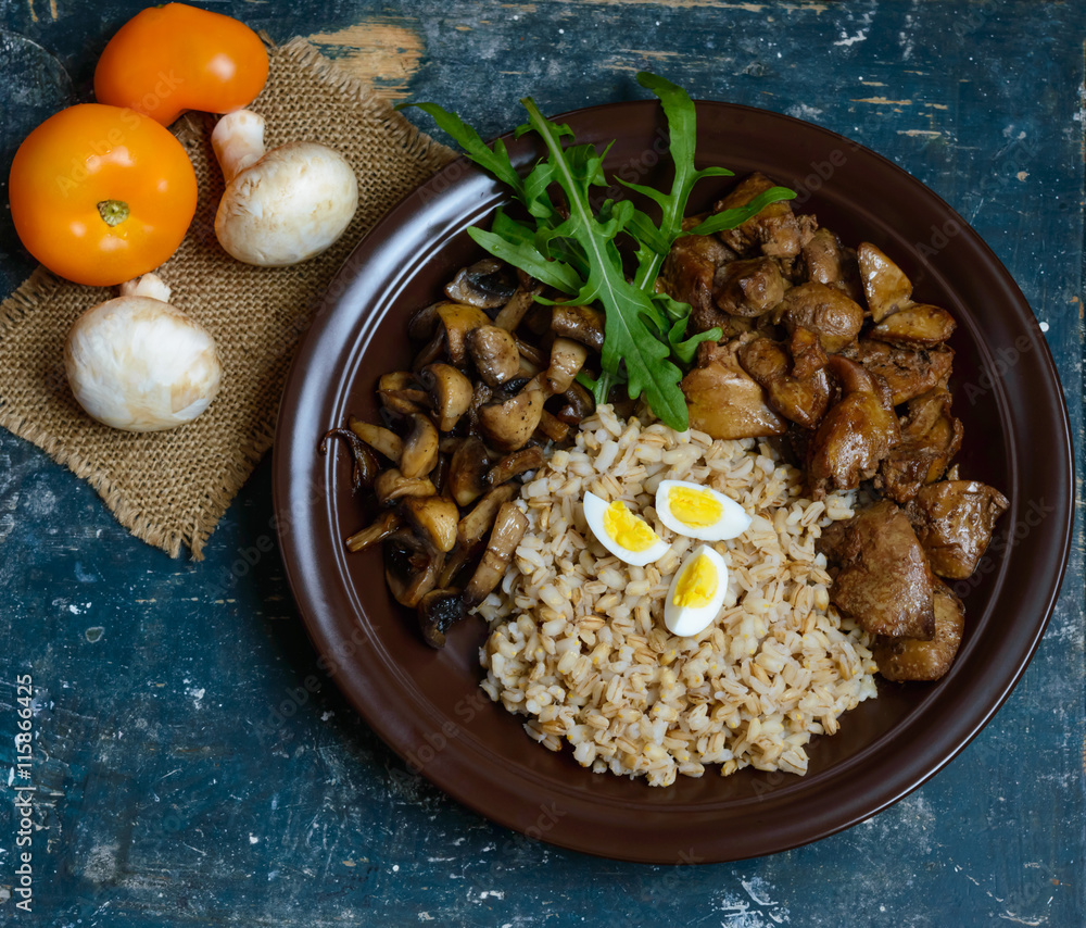 Fototapeta premium Barley porridge, fried mushrooms and duck liver, boiled quail eggs, tomatoes, arugula - healthy food. The top view
