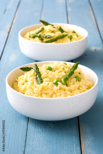 Risotto with asparagus, parsley and peas on a blue wooden table

