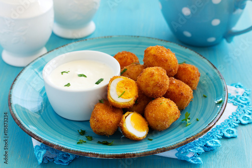 Billede på lærred Quail eggs, deep fried with white sauce.