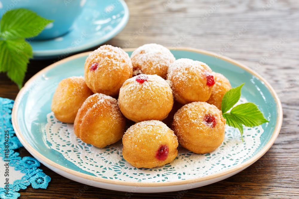 Donuts filled with raspberry jam and powdered sugar in. Donuts filled with raspberry jam and powdered sugar in.
