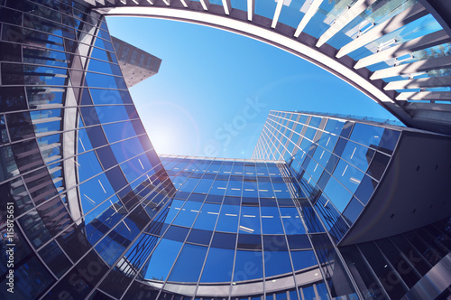 Office building from low angle. Blue sky and flare reflections. Empty copy space for editor's text.