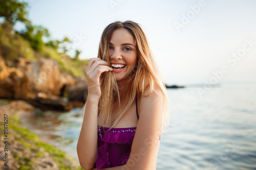 Beautiful young cheerful girl rests at morning beach © Cookie Studio