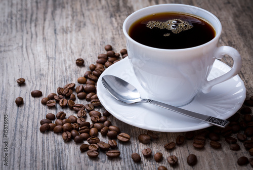 Tasse Kaffee mit Kaffeebohnen auf Hintergrund aus Holz. Frontans