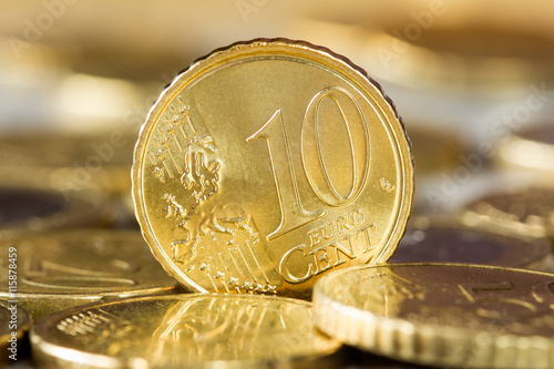Ten euro cent standing between other coins photo