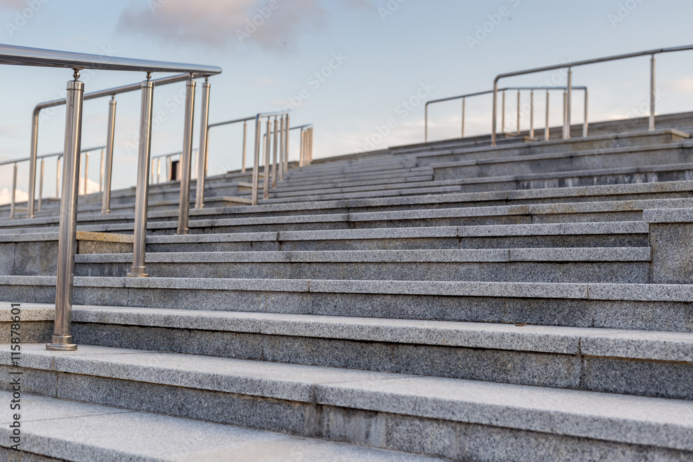 Fototapeta premium Public metal chrome handrail on gray staircase at city