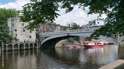 Pedestrians cross Lendal Bridge in York. Lendal Bridge spans the River Ouse which divides the city. One second time-lapse delay.