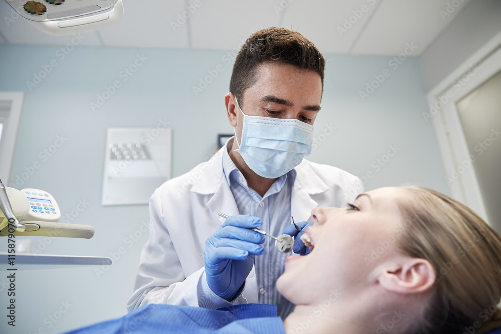 male dentist in mask checking female patient teeth male dentist in mask checking female patient teeth