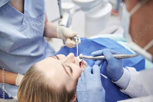 close up of dentist treating female patient teeth