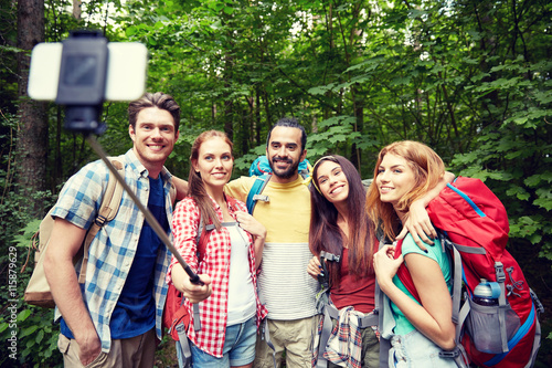 friends with backpack taking selfie by smartphone