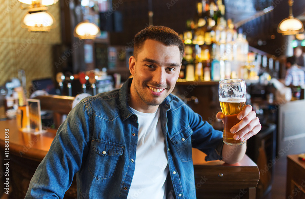 happy man drinking beer at bar or pub happy man drinking beer at bar or pub