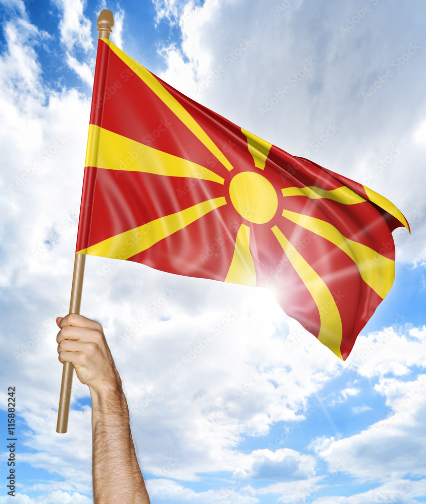 Person's hand holding the Macedonian national flag and waving it in the sky, 3D rendering Person's hand holding the Macedonian national flag and waving it in the sky, 3D rendering