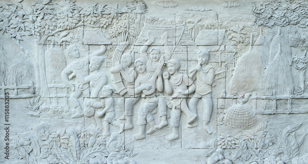 Stone carving of traditional Thai musical instrument on temple wall