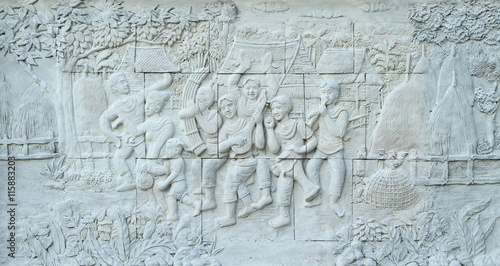 Stone carving of traditional Thai musical instrument on temple wall