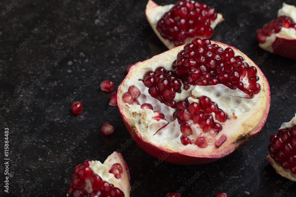 Red juicy pomegranate on dark marble background. Healthy, antioxidant, fresh, gourmet, delicious, organic fruit. Ingredient for grenadine. Close-up and copy space. Red juicy pomegranate on dark marble background. Healthy, antioxidant, fresh, gourmet, delicious, organic fruit. Ingredient for grenadine. Close-up and copy space.