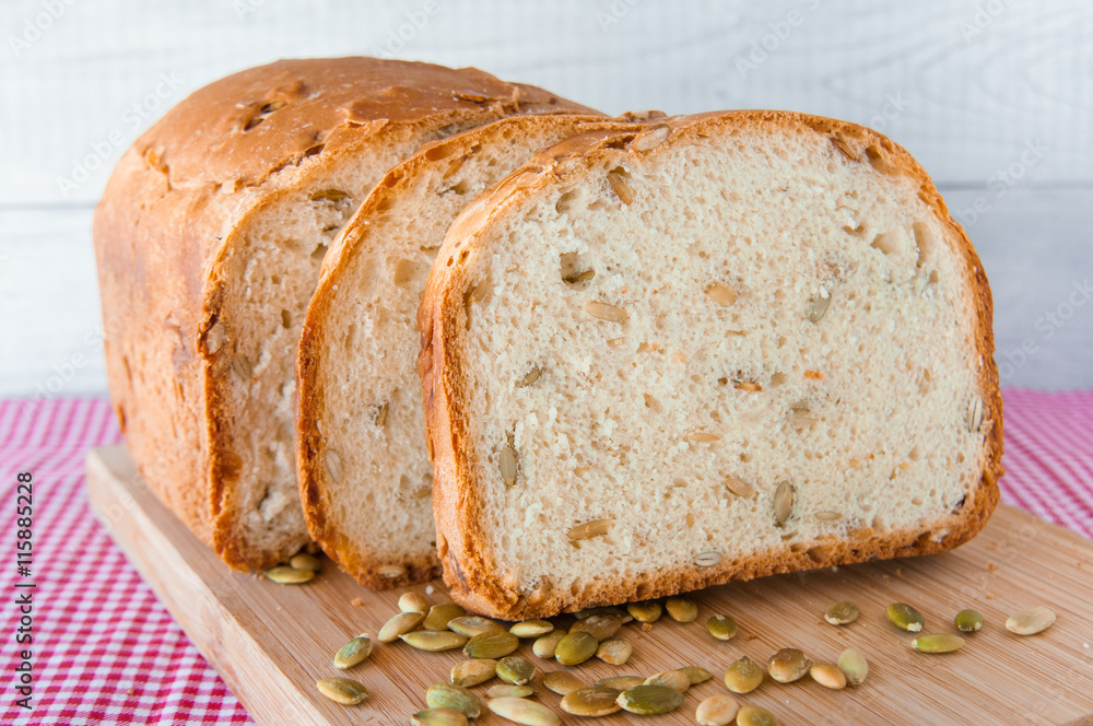 Loaf of white bread with green pumpkin seeds Loaf of white bread with green pumpkin seeds