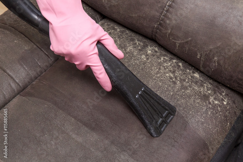 Professionally nozzle making free natural leather sofa from dust. Early summer cleaning or regular clean up. Upholstered furniture.