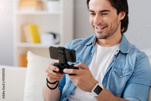 Joyful smiling handsome man playing video games