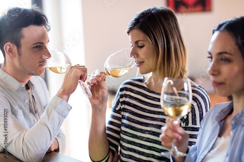 Friends drinking wine by counter