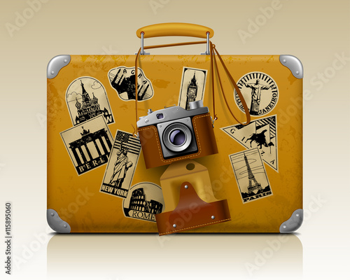 Old small threadbare suitcase with a retro photo camera