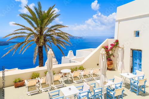Terrace with chairs and tables in Firostefani village with typical white Greek architecture, Santorini island, Greece