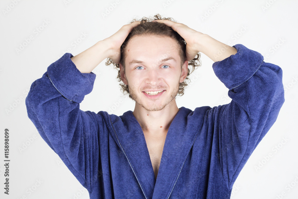 Happy handsome man in bathrobe touching his hair. Man smiling with teeth. Happy handsome man in bathrobe touching his hair. Man smiling with teeth.