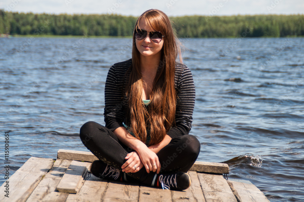 smiling girl sitting on a jetty