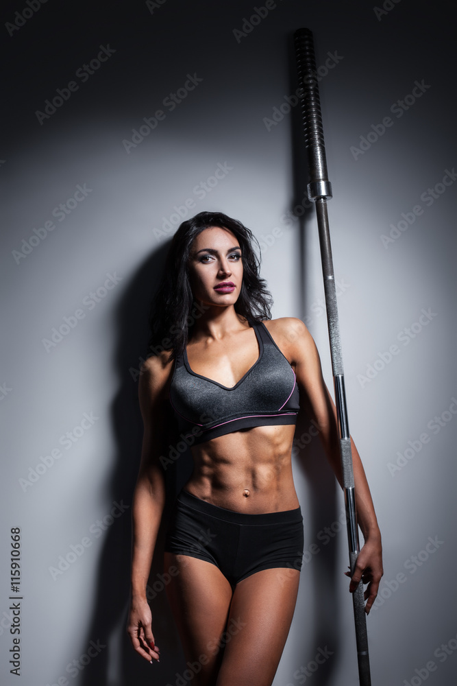 studio shot of perfect body of bodybuilder female with barbell; studio shot of perfect body of bodybuilder female with barbell;