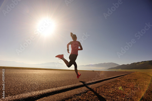 healthy lifestyle young woman runner running on sunrise seaside road