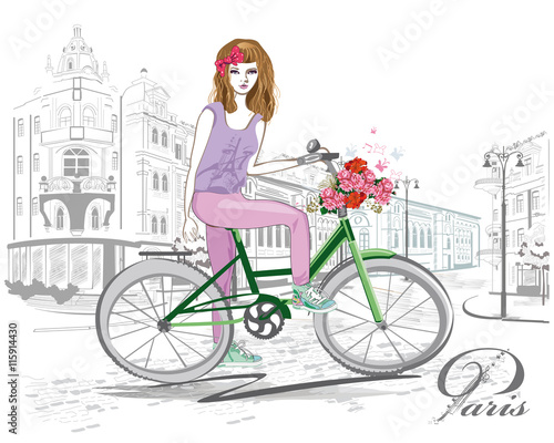 Fashion girl rides a bicycle the streets of the old town.