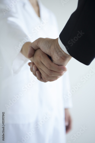 握手する医者とビジネスマン