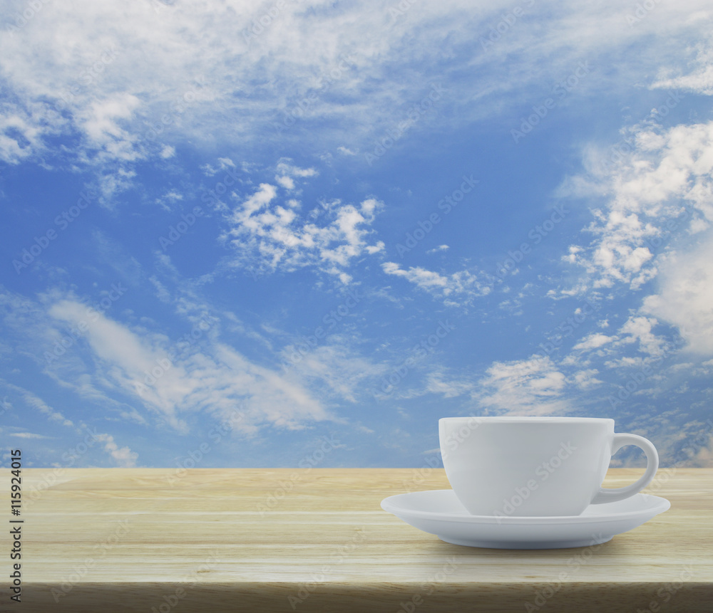 White coffee cup on wooden table and blue sky