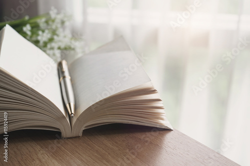 Close up of open book with flower in the morning
