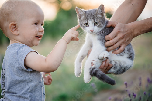 Child playing with cat in garden.