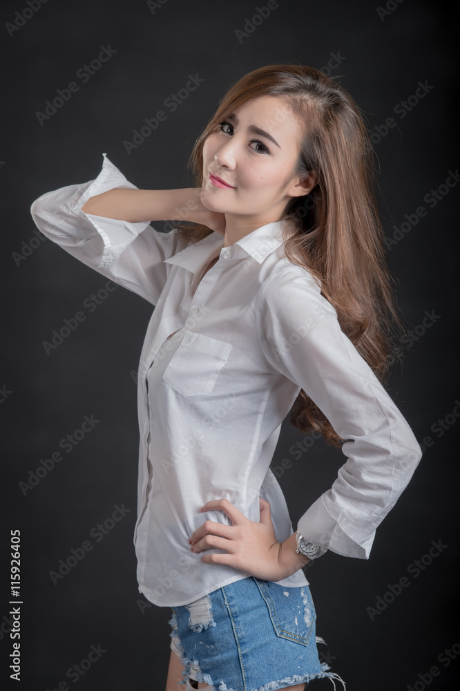 Portrait of model beautiful girls wearing White shirt and short jeans in clean skin beautiful and smart concept with Black .fabric background Portrait of model beautiful girls wearing White shirt and short jeans in clean skin beautiful and smart concept with Black .fabric background