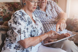 Retired couple at home using touch screen computer