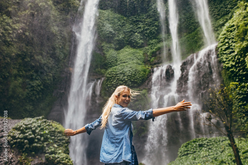 Tourist enjoying by a waterfall in forest