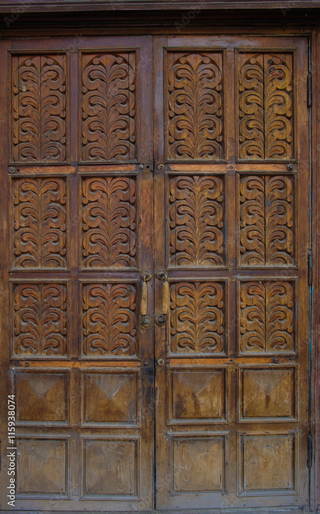 The old wooden doors of the 19th century with elements of plants ornament