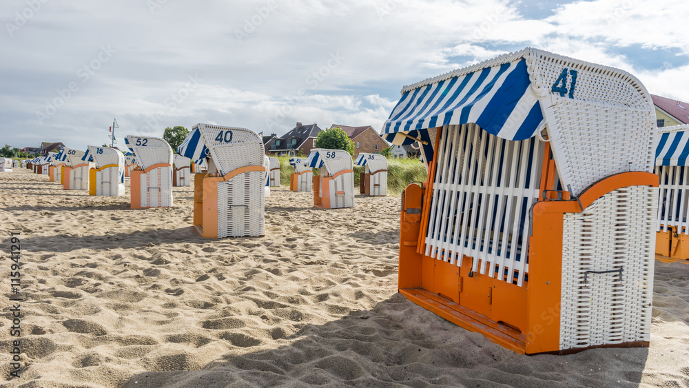 Bad summer weather comes up at a beach with beach chairs