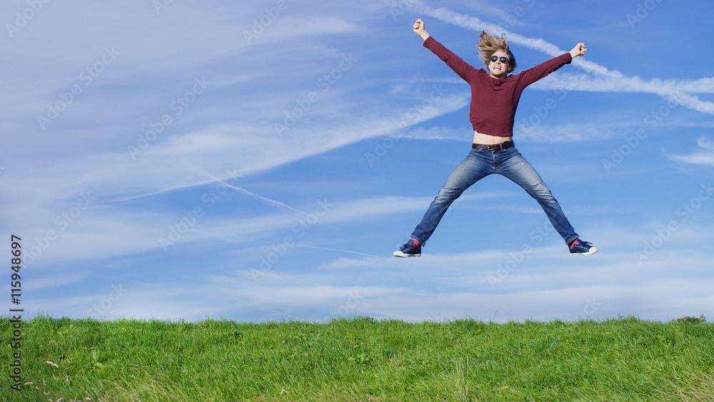 Happy man jumping for joy on grass, with space for text Happy man jumping for joy on grass, with space for text